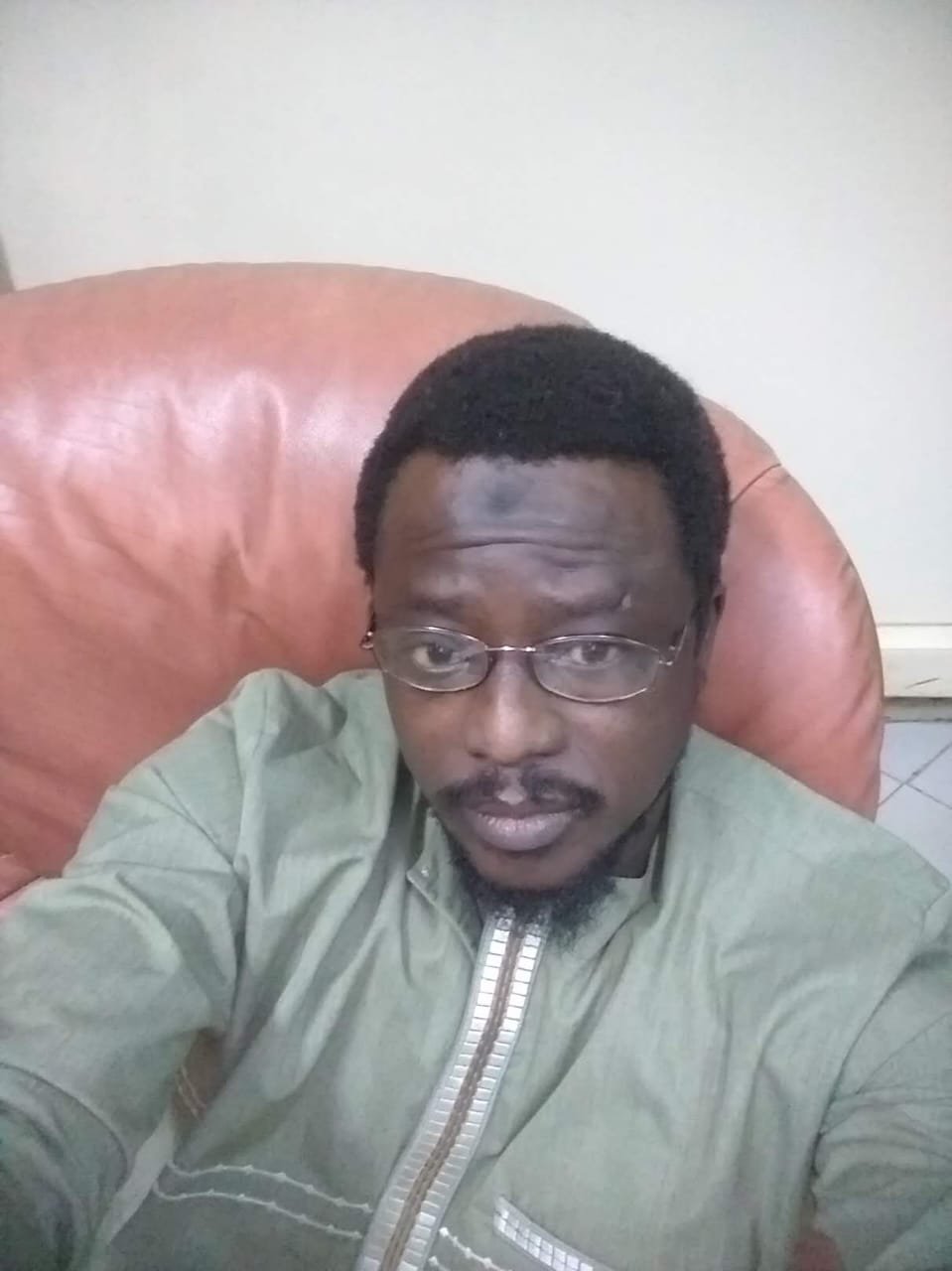 Portrait de Mouhamed Diop, en boubou vert et lunettes